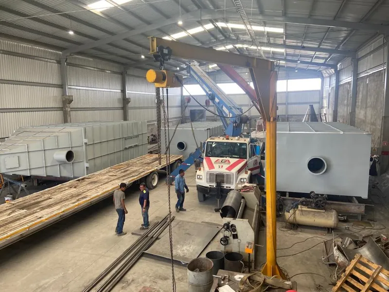 Montaje de equipo dentro de la nave con grúa y plataforma.